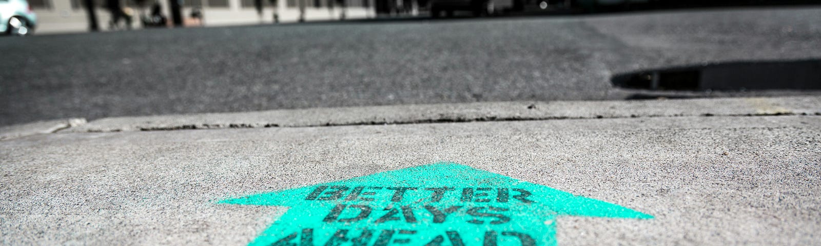 A message painted on the ground that says, “BETTER DAYS AHEAD”