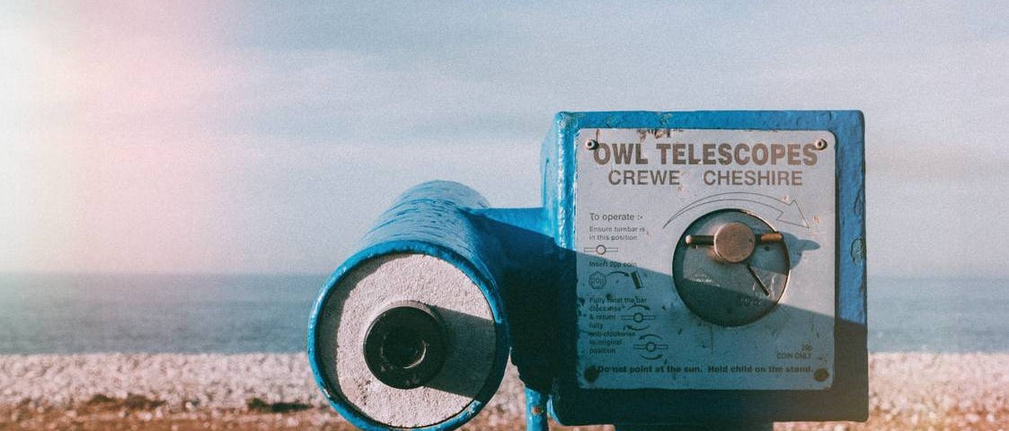 An old industrial telescope pointing toward the beach