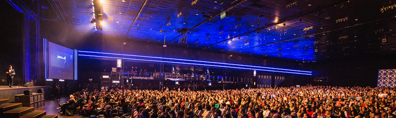 A large audience looking towards an small stage