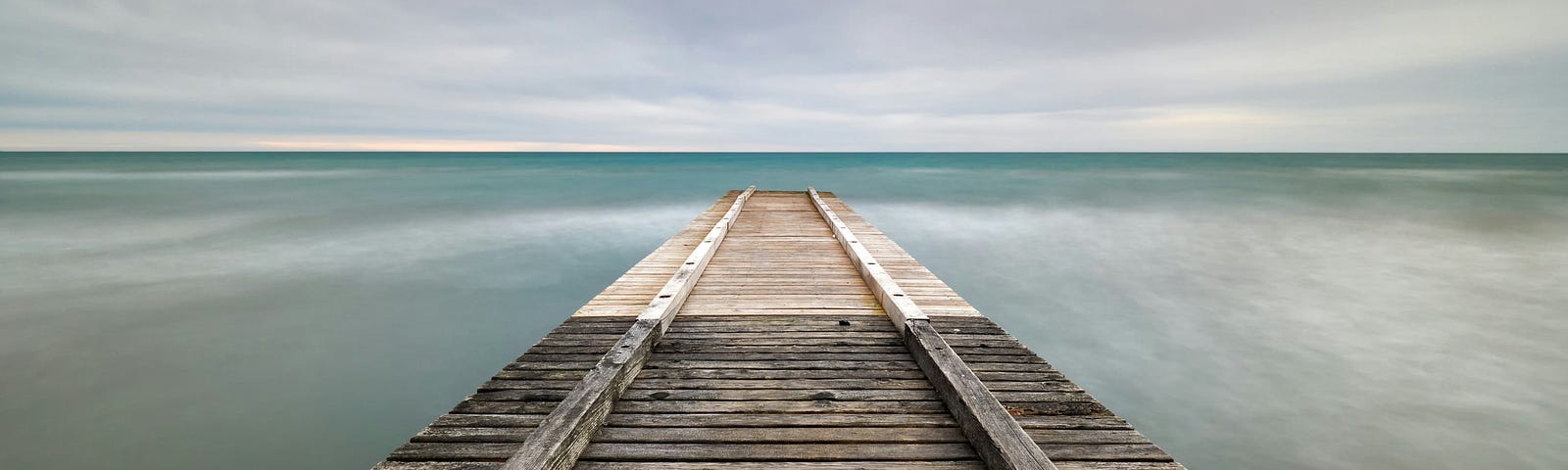 A long wooden boardwalk overlooking the sea.