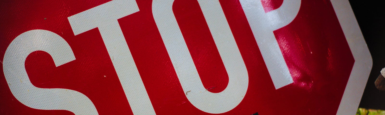 A close up of a stop sign that has “in the name of love” written underneath it.