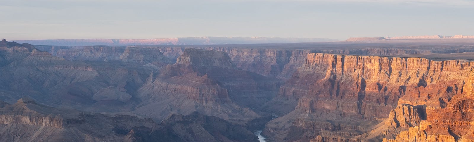 A birds eye view of the Grand Canyon, with the Colorado River cutting through.