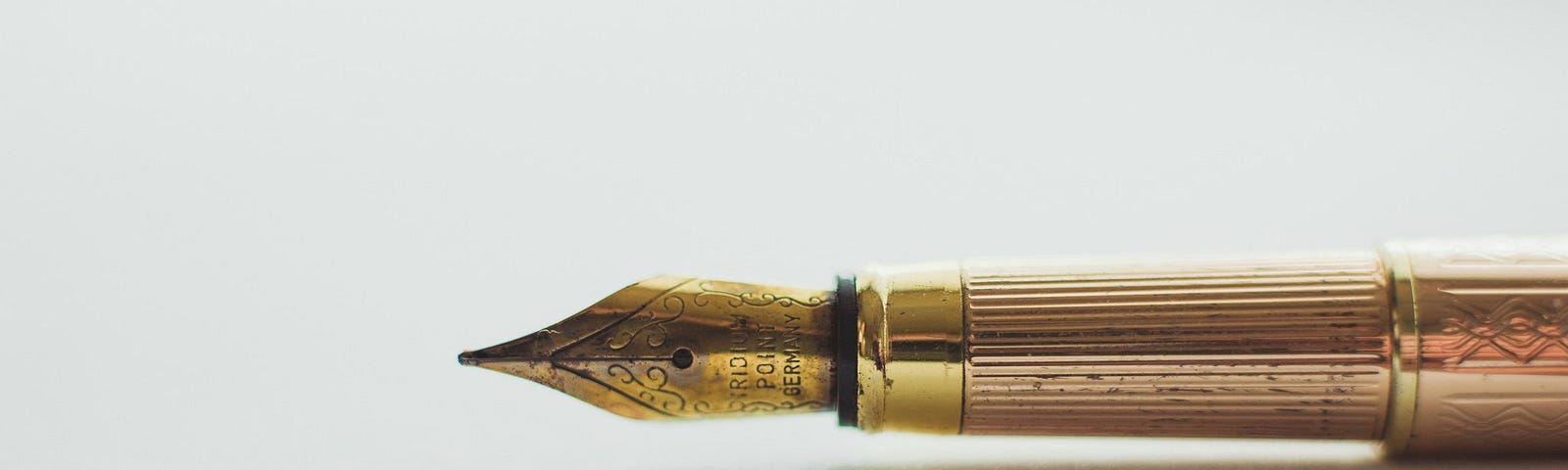 A gold fountain pen on a white background.