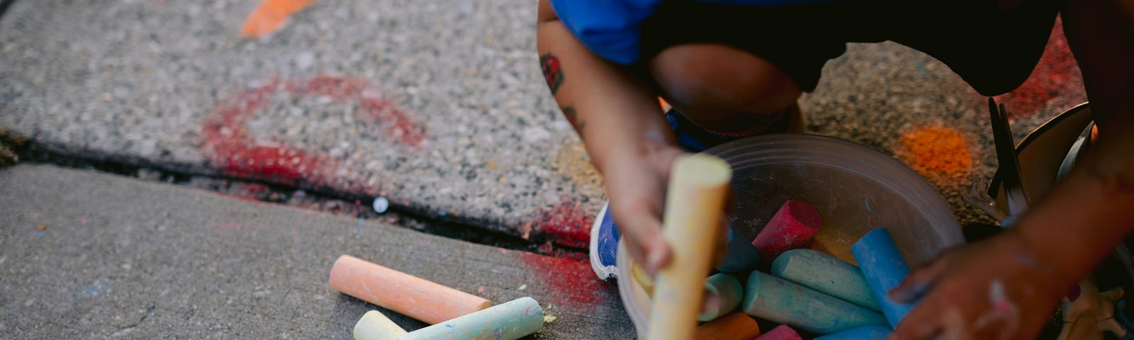 Child playing with chalk on the street