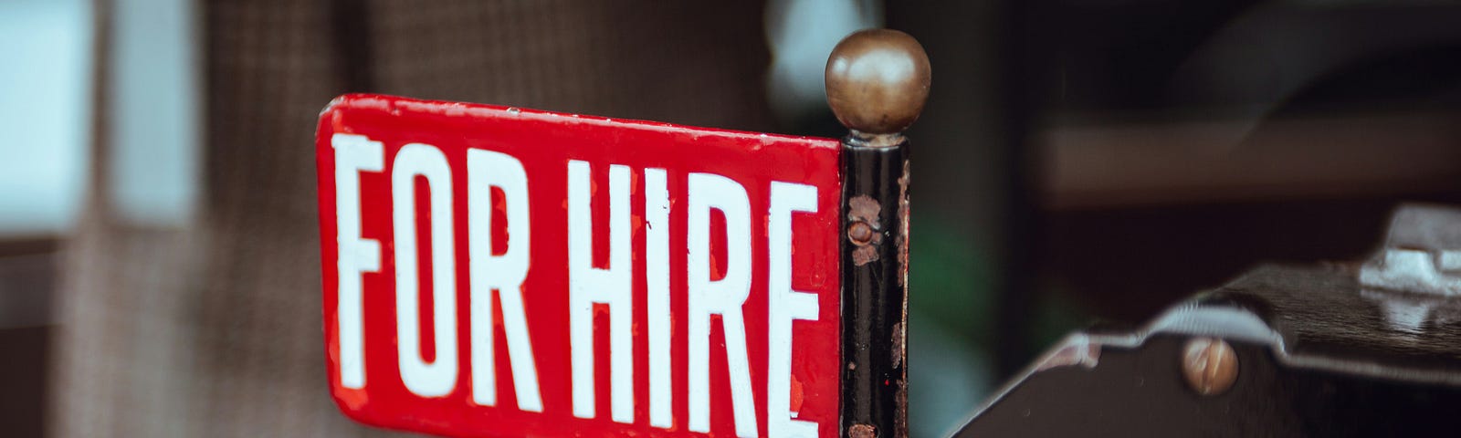 A red sign that reads For Hire