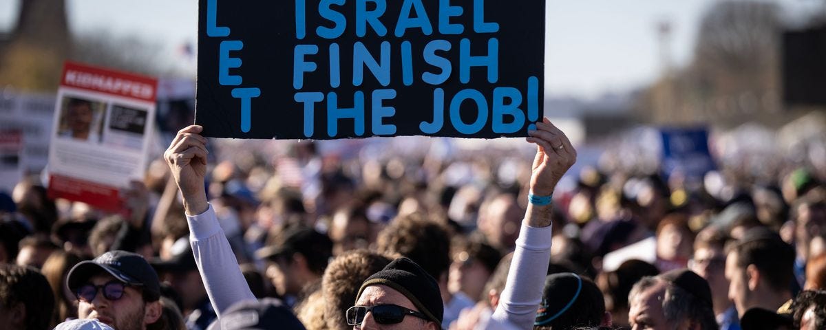 The DC Pro-Israel march, with a man holding a sign that reads ‘Let Israel Finish The Job’