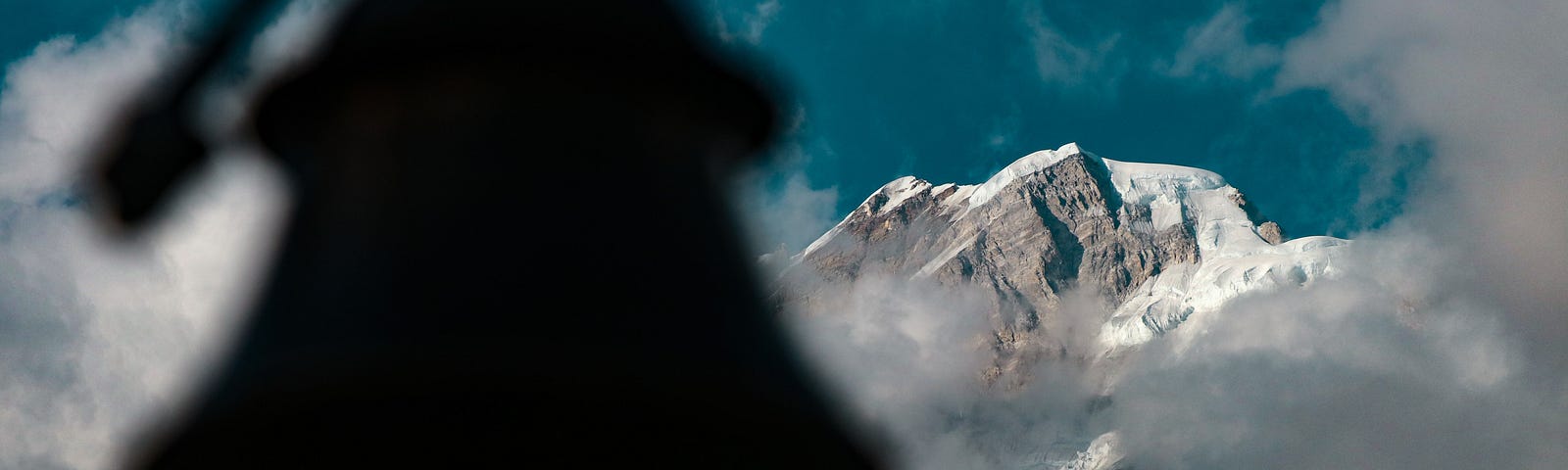 view of a snow-covered mountain range with a bell in foreground