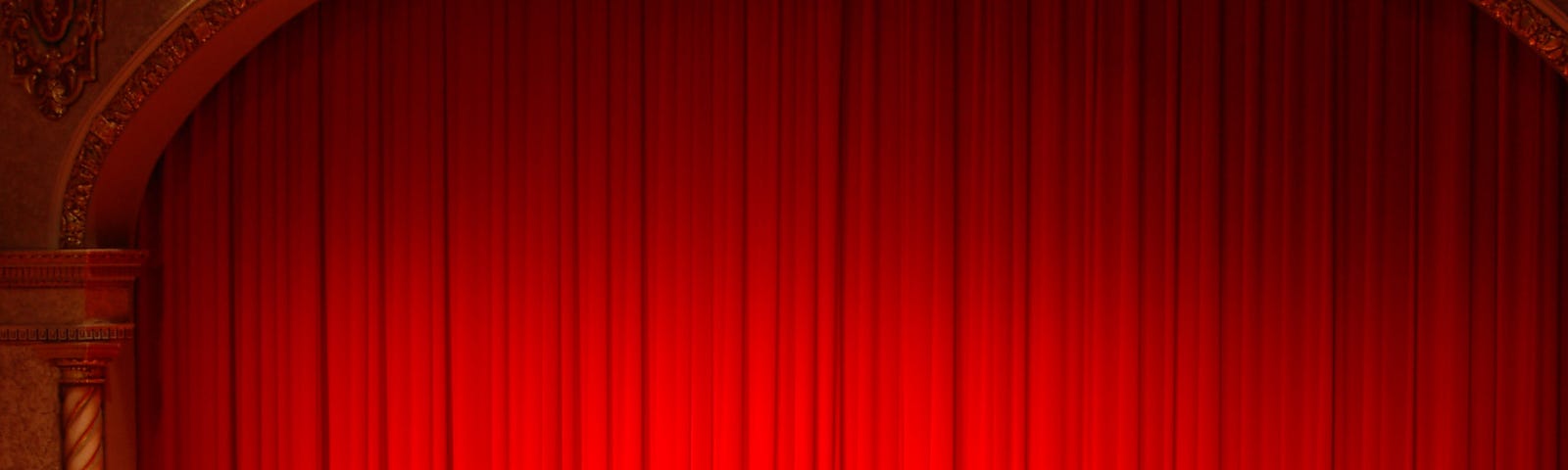 A stage with a red curtain before a play.