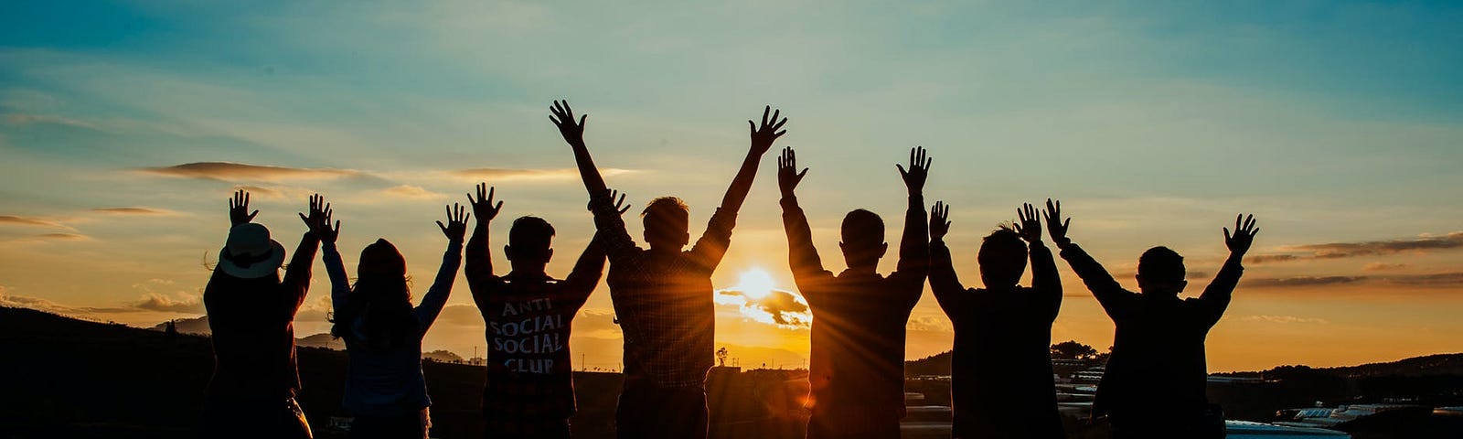 a group of people stretching their arms out to the sun