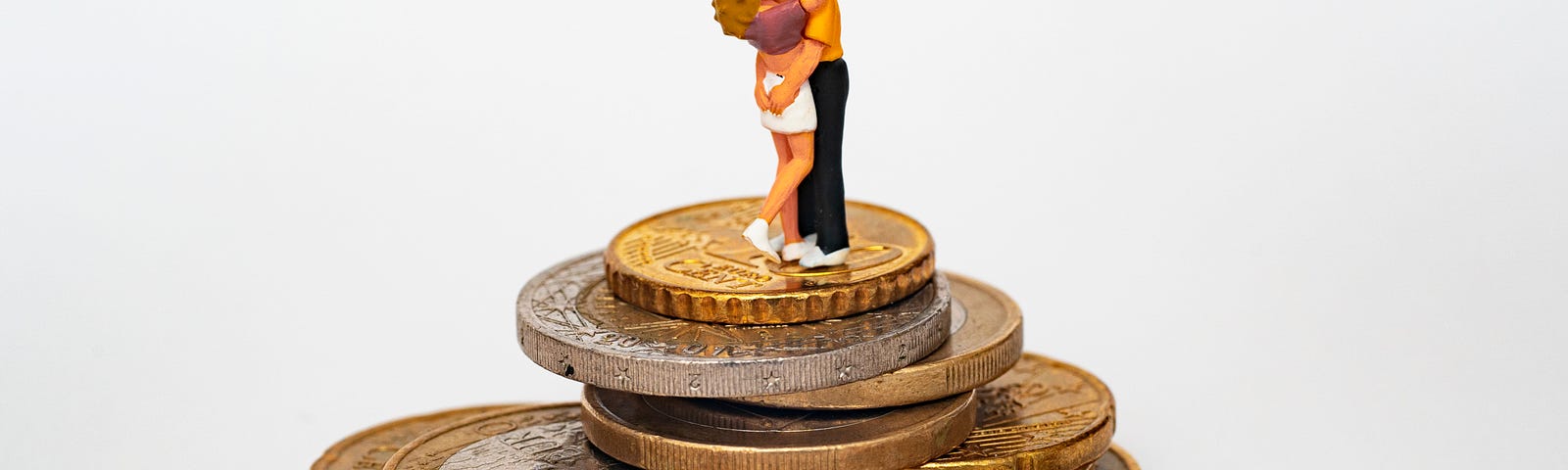 man and woman kissing on top of gold coins