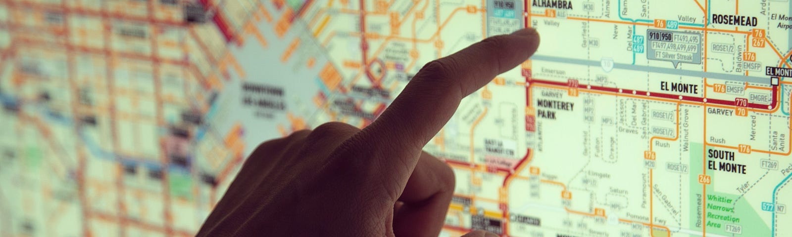 Mapa com dedo apontando um local
