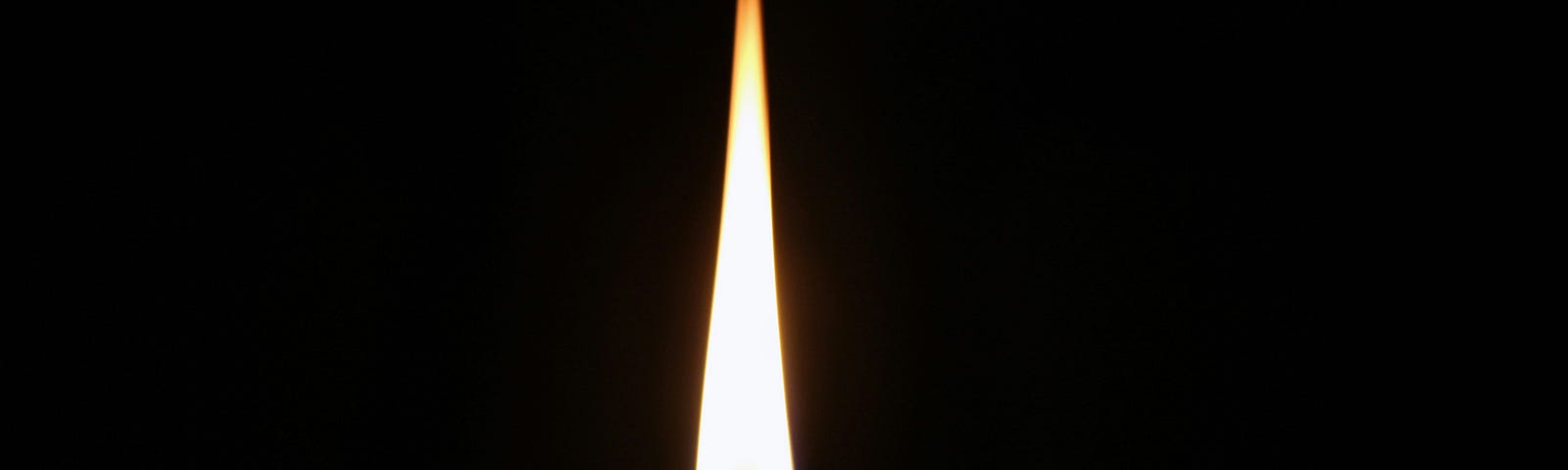 Image of a candle flame with a dark background.