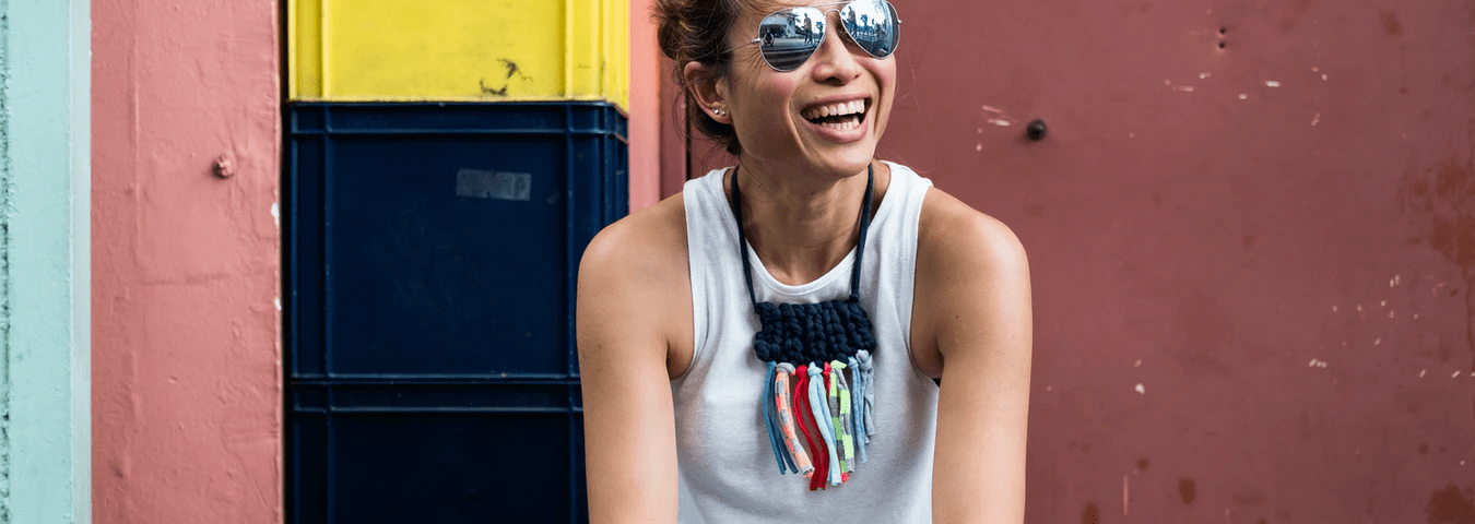 Woman sitting on front steps looking at cell phone, smiling