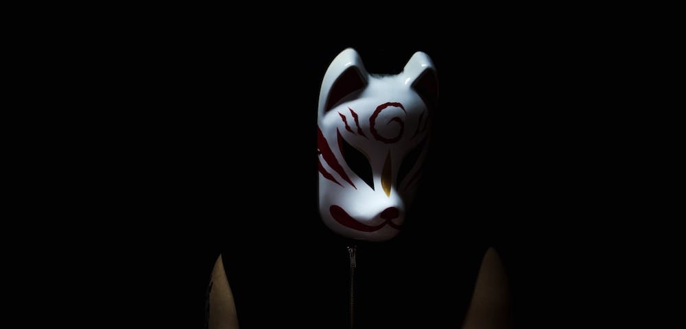 Photo of a masked man emerging from the shadows