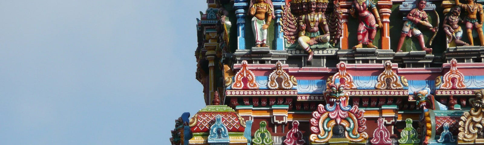 Picture of an entrance tower in a Hindu temple sporting sculptures of deities and mythical beings
