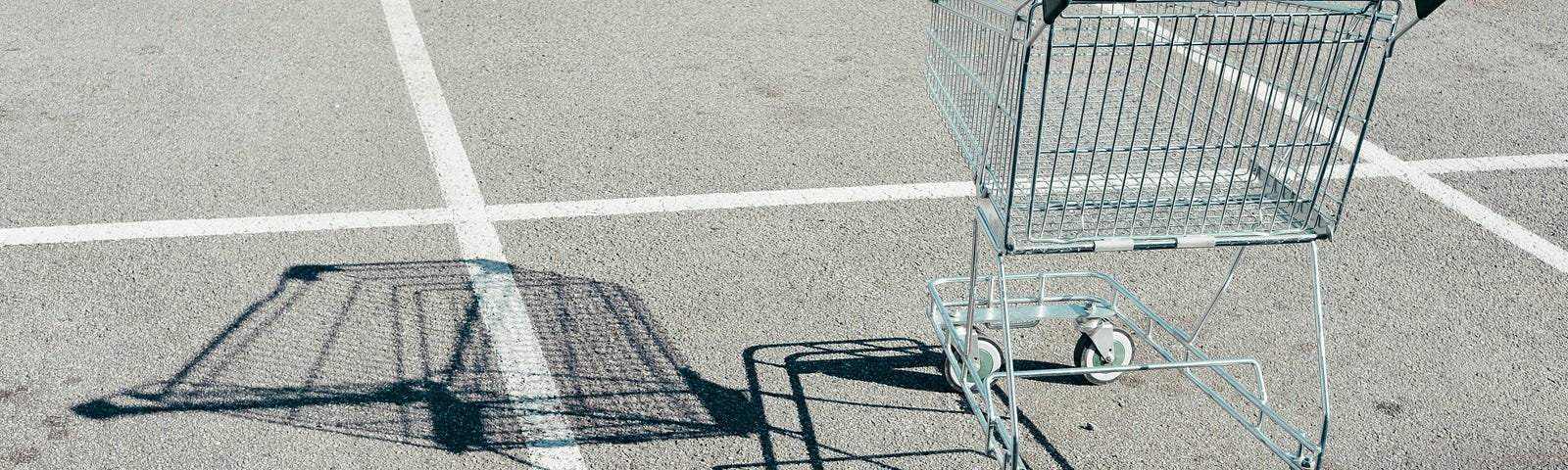 A lone shopping cart in an empty parking lot. Was it abandoned by someone who does not align with the The Shopping Cart Theory?