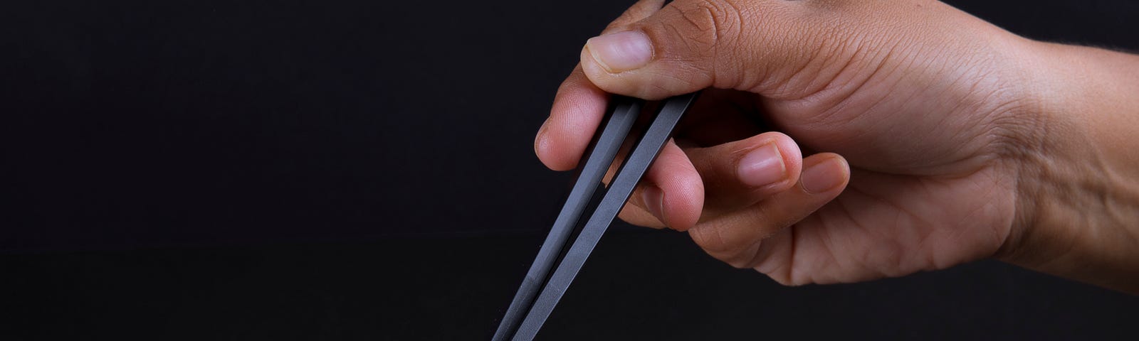 An arm extends from the upper right, its hand holding chopsticks that lift noodles from a plate of food. Intermittent fasting does not appear to have an advantage for weight loss, compared with other calorie restriction approaches.