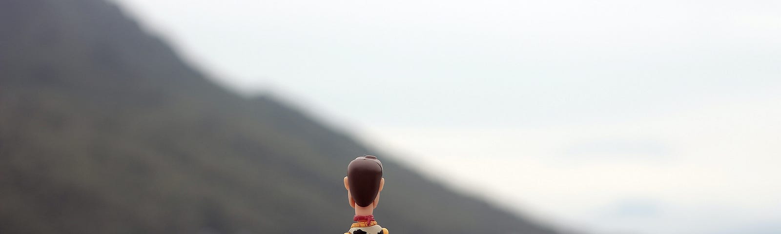 Action figure from Toy Story sitting on a pier