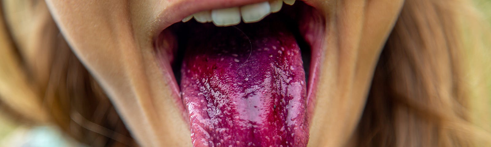 A woman sticking out a purple tongue at the camera.