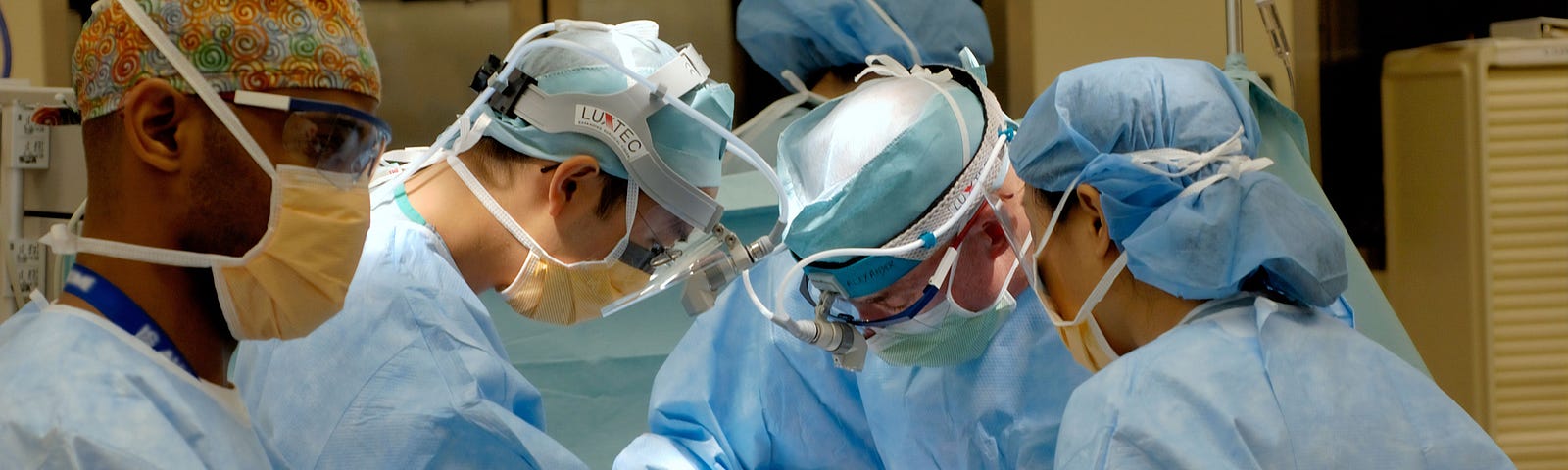 A team of medical people, engaged in replacing a patient’s hip with a prosthetic one.