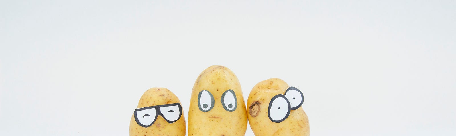 3 potatoes with eyes on a white background