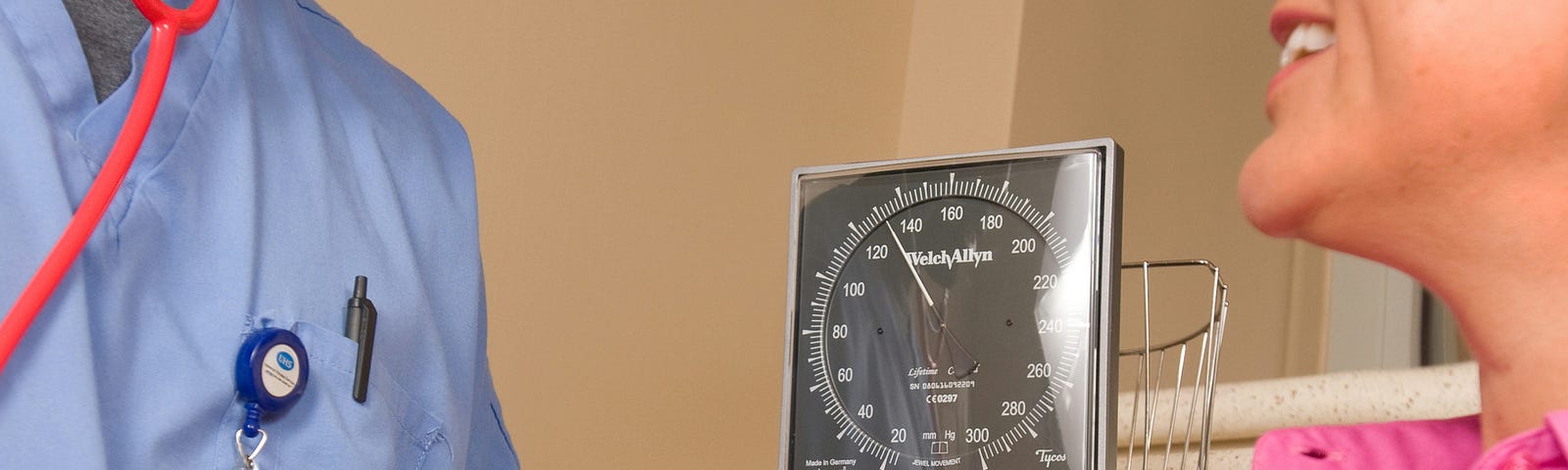 A male nurse checks a patient’s blood pressure.