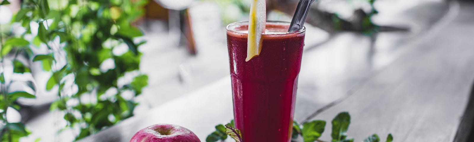Glass of beetroot juice with an apple and beetroot on the side