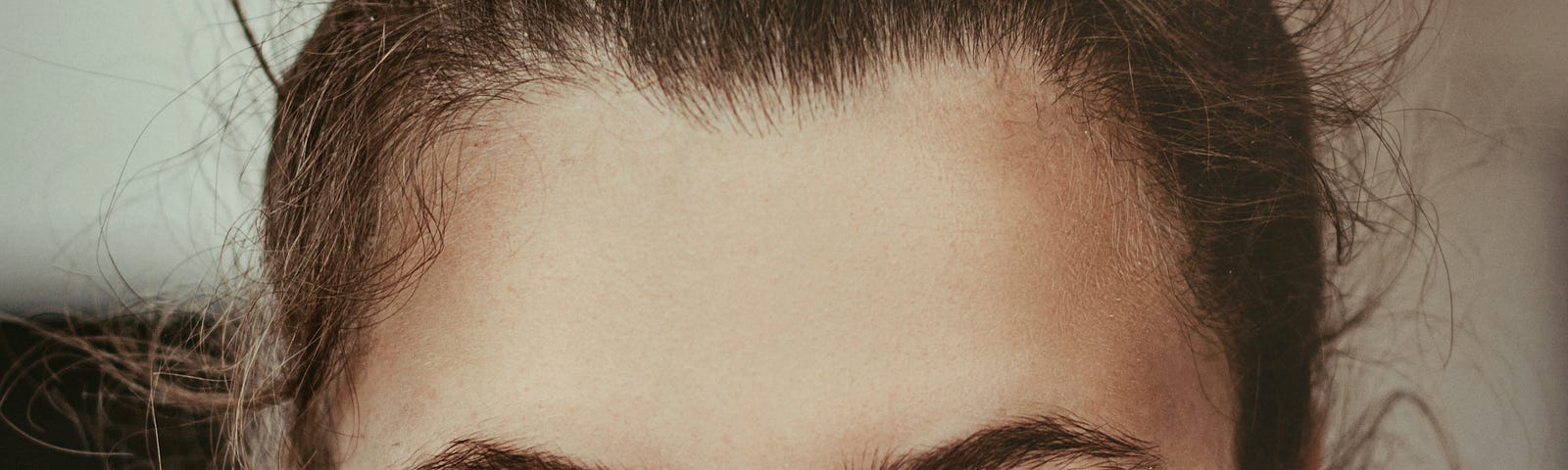 A woman’s face, freckles, hair up
