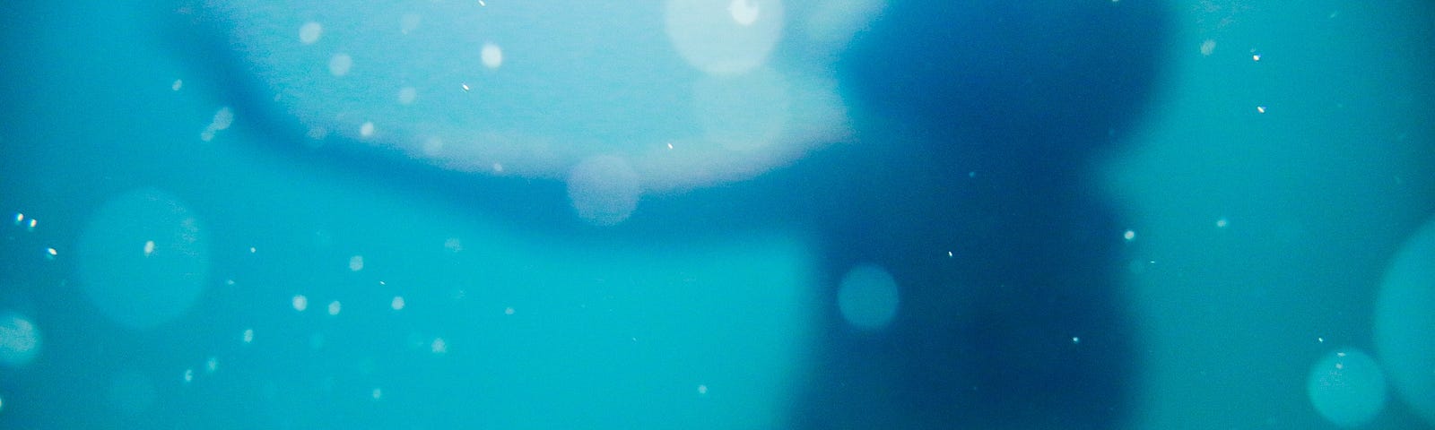 Blurry female figure swimming in deep water