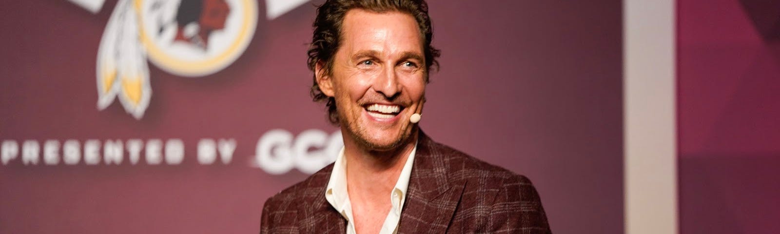 Image of Matthew McConaughey seated on stage at an event.