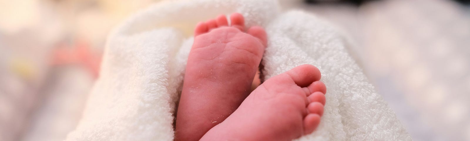 Baby’s soles peeking out of a white blanket