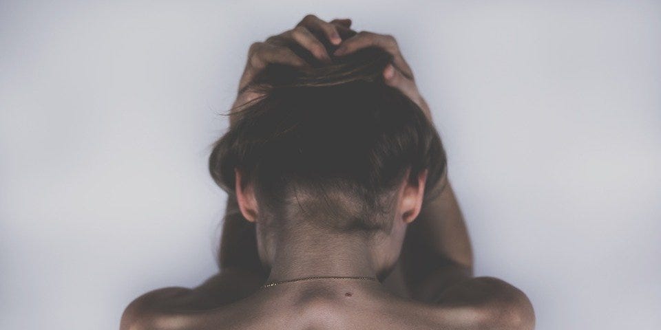Woman naked holding her head