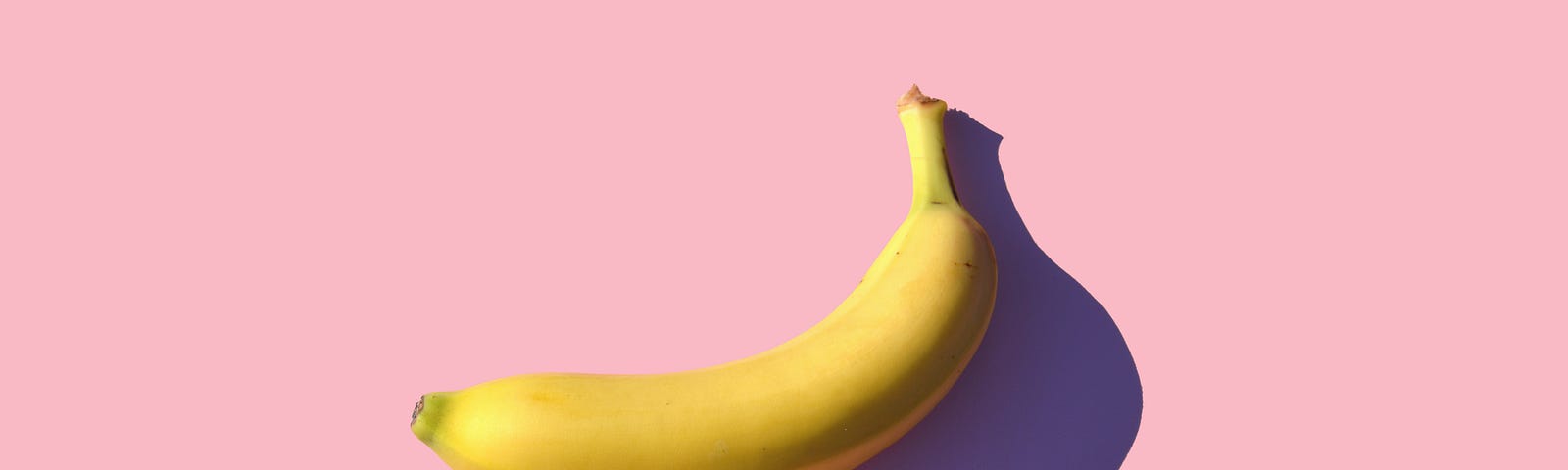 A banana in a pink backdrop