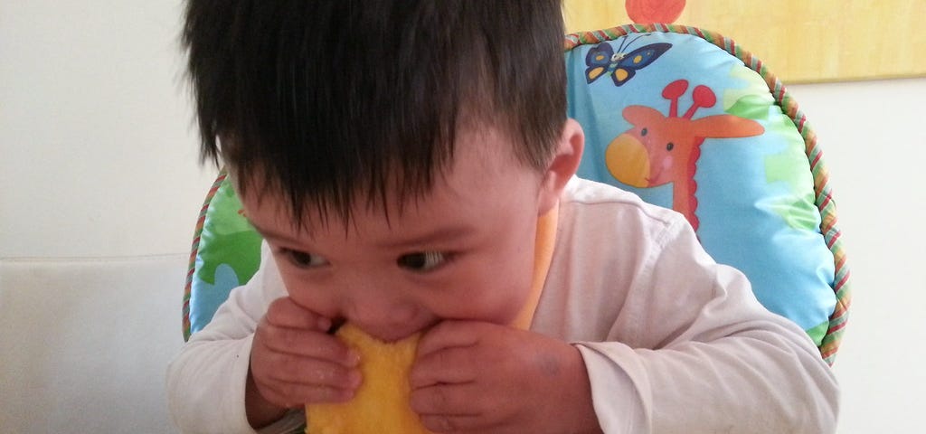 baby eating mango