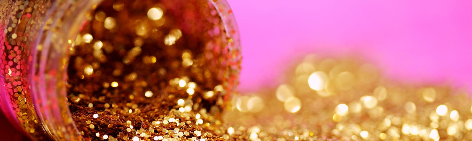 Bottle of gold dust, spilling. Pink background