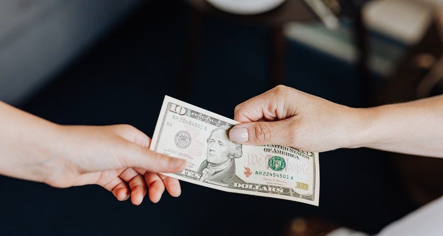 Hands Holding a 10 Dollar Bill