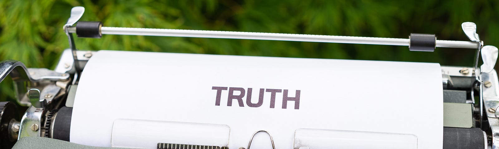 An image of a typewriter with a white paper in it, and the word ‘TRUTH’ written on it.