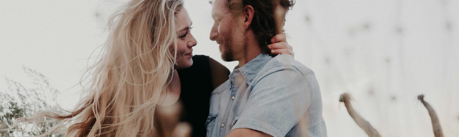 A man and woman holding hands and looking at each other lovingly.