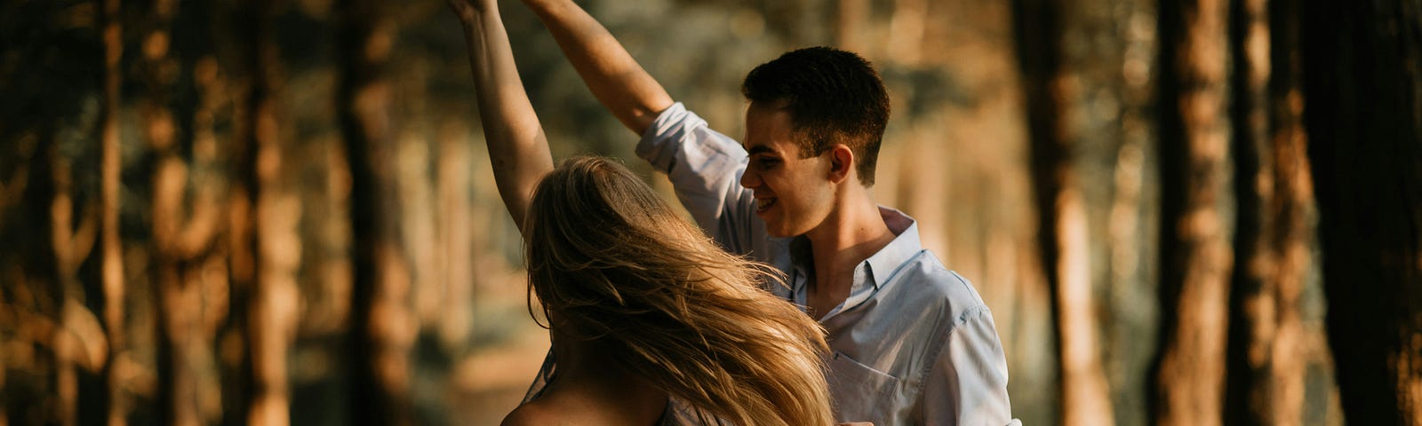 a man and woman dancing in the woods, very romantic