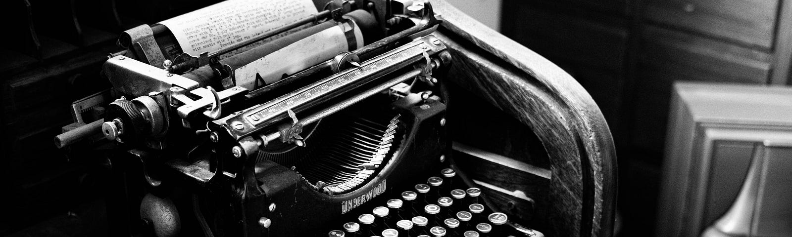 old black & white typewriter on a crowded desk