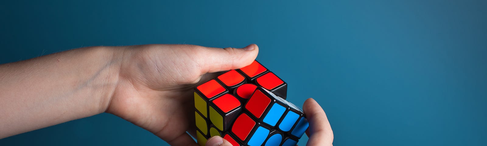 Hands completing a Rubiks cube
