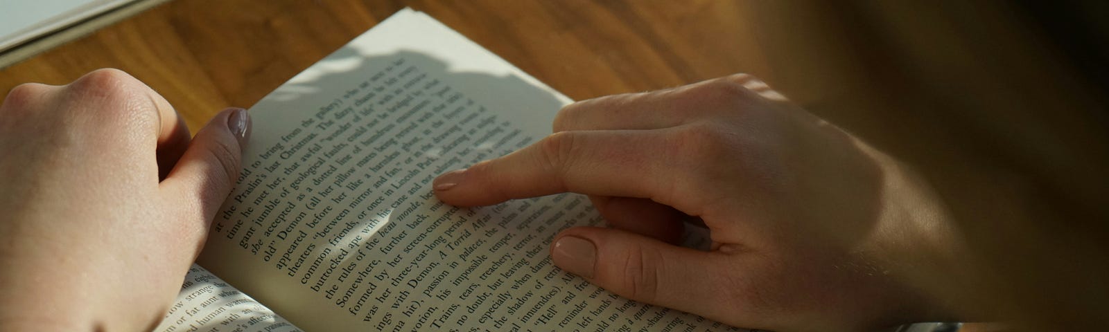 Someone reading a story in a book, following their finger