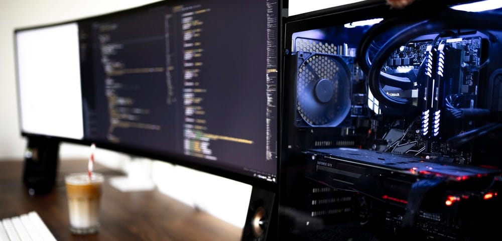 A blured screen and hardware part of a computer with neon