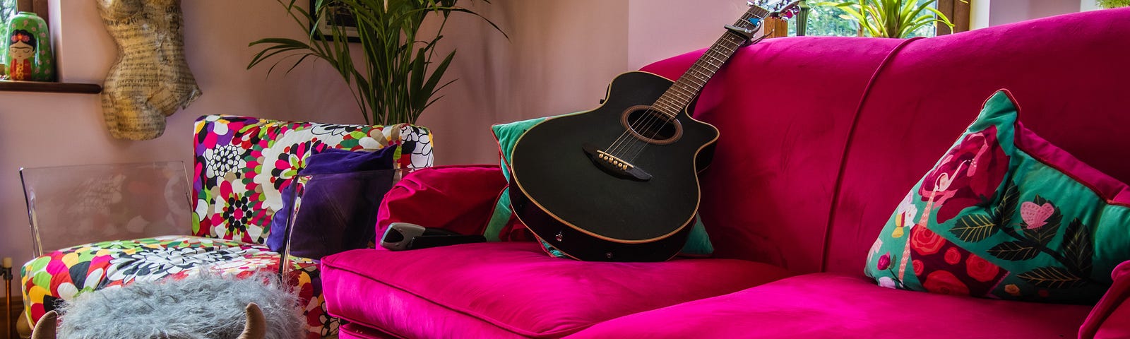 hot pink couch with a black guitar on it