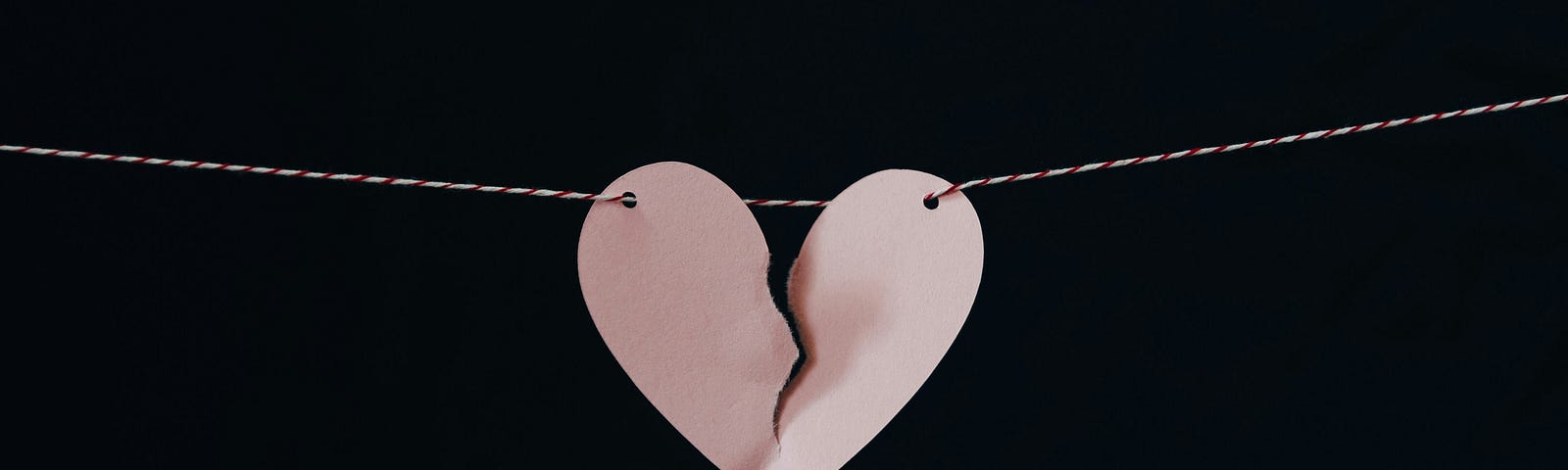 pink heart split down the middle hanging on a string