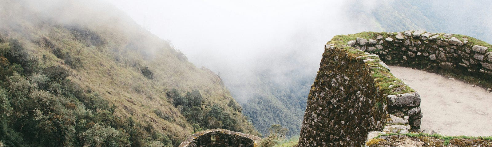 Ancient stone walls slither in verdant and foggy hills.