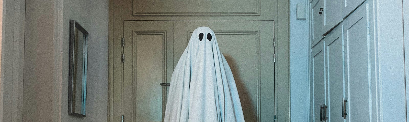 Costume made to look like a ghost in the middle of a room.