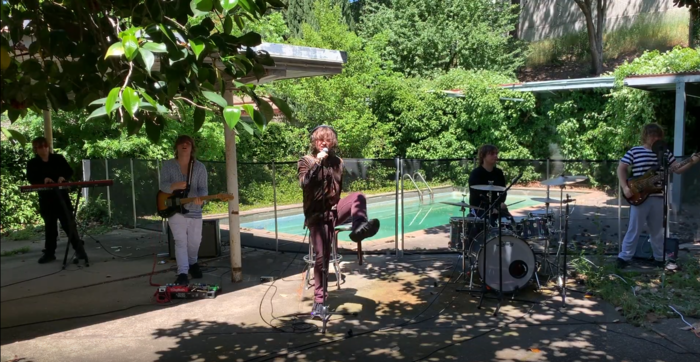 From a (now deleted) live video; five Christians in a spilt screen effect playing instruments in front of a backyard pool shaded by trees — left to right keyboard, guitar, vocals, drums, bass guitar — vocals has left leg kicked up