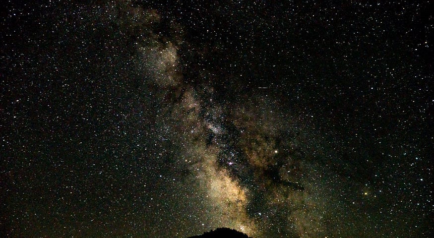 The Milky Way Galaxy stretches across the night sky.