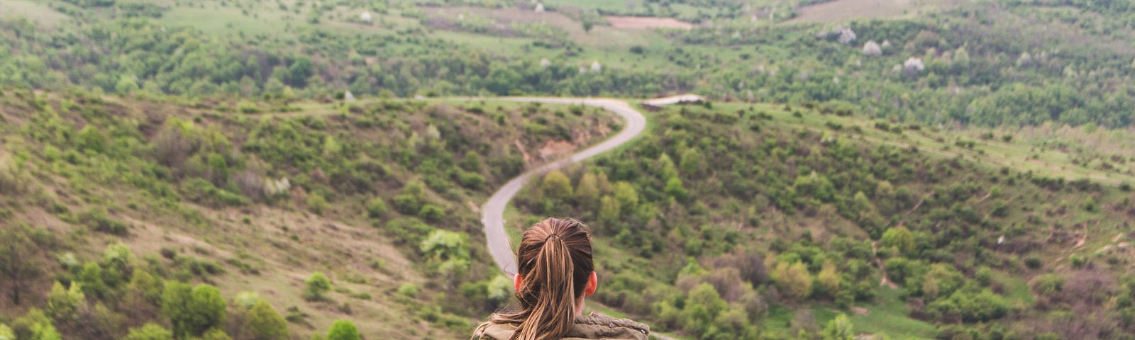 women sitting overlooking a winding road